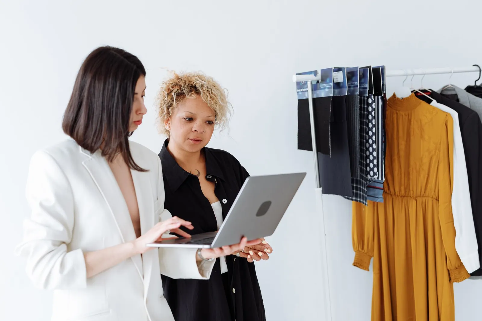 Two designers reviewing work on a laptop during a mentor feedback session